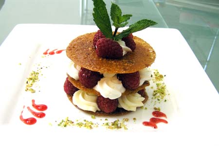 Millefeuille of Macadamia Tuile with Raspberries and Aniseed Cream Dust of Pistachio and Raspberry Coulis